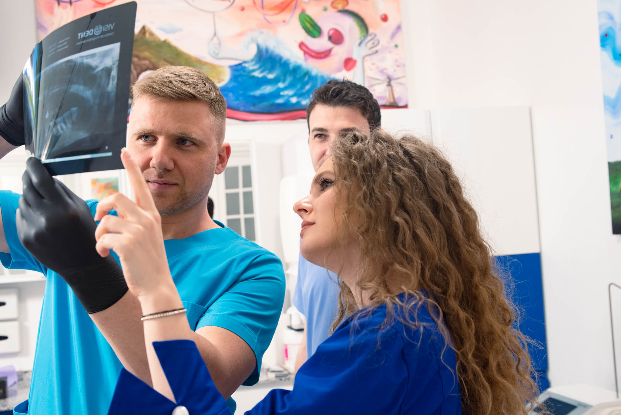 Dislocarea articulației temporo-mandibulare Doi medici și un asistent analizând o radiografie într-un cabinet medical.