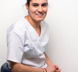 Diana Paun într-un halat alb, zâmbind în fața unui fundal alb, indicând un cadru medical profesionist din cabinetul Dr. Aristide, București