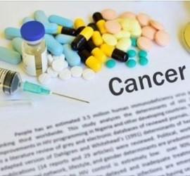 O varietate de medicamente și un stetoscop pe un document cu cuvântul 'Cancer'.