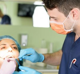 Medic stomatolog care examinează un pacient în timpul unei proceduri dentare.