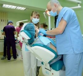 Medic stomatolog efectuează o procedură pe un pacient în cabinetul dentar.