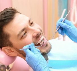 Un dentist examinează un pacient în timpul unei consultații dentare.