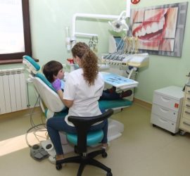 Medic stomatolog care examinează un pacient într-un cabinet stomatologic modern.