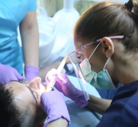 Medic stomatolog efectuează o intervenție dentară asupra unui pacient în cabinetul stomatologic.