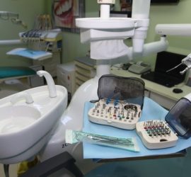 Set de instrumente dentare așezate pe un scaun de dentist în cabinetul stomatologic.