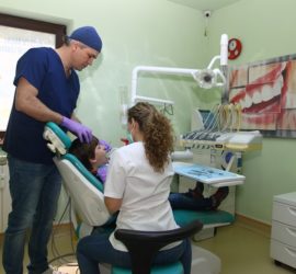 Medic stomatolog cu mănuși examinând un copil într-un cabinet stomatologic.