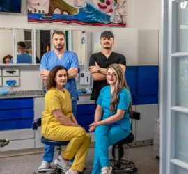Patru cadre medicale in univorme colorate zambesc in cabinetul stomatologic