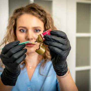 Medic stomatolog pune bonding pe aplicator in cabinetul stomatologic