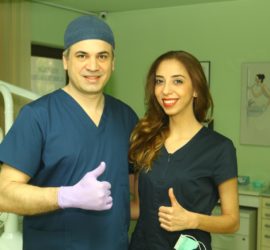 Doi profesioniști medicali, un bărbat și o femeie, îmbrăcați în uniforme, zâmbind și făcând semn de aprobat.