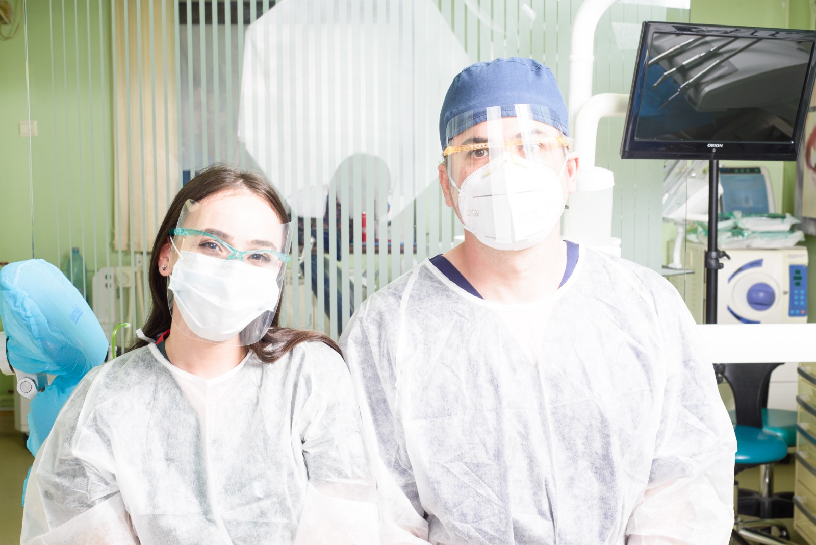 Conexiunea dintre tulburările de somn și cavitatea orală Două persoane în echipament de protecție medicală, cu măști și viziere, într-un cabinet medical.