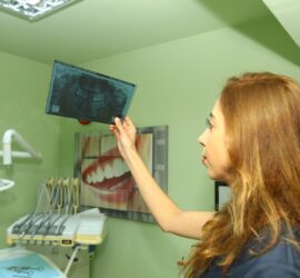 Medic dentar care examinează o radiografie dentară într-un cabinet medical.