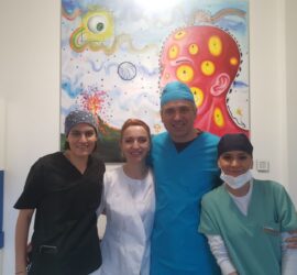 Patru membri ai unei echipe medicale pozând împreună, îmbrăcați în uniforme de lucru.