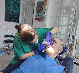 Medic stomatolog examinând un pacient în timpul unei proceduri dentare într-un cabinet modern.
