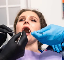 Femeie pe scaun la dentist cu multe instrumente medicale in gura