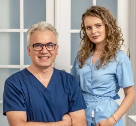 Medici stomatologi zambind imbracate in uniforma medicala in cabinetul stomatologic