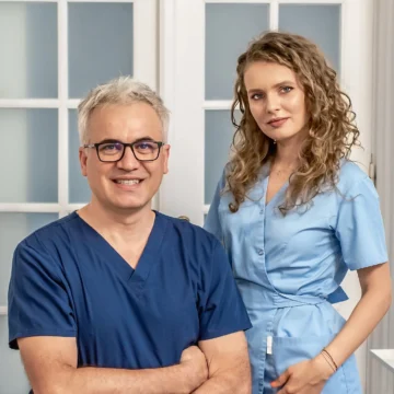 Medici stomatologi zambind imbracate in uniforma medicala in cabinetul stomatologic