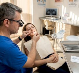 Medic stomatolog verifică sănătatea gingiilor într-un cabinet modern și luminos.