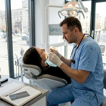 Medicul stomatolog examinează coroana dentară a pacientului pentru a se asigura că este bine fixată și funcționează corect.