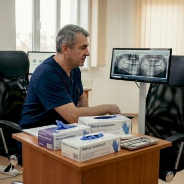 Medicul dentist analizează o radiografie dentară pentru a evalua sănătatea dinților.