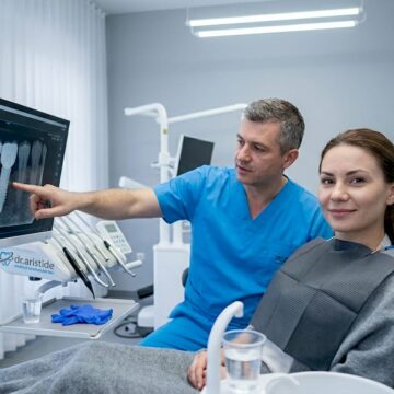 Medicul stomatolog discută cu o pacientă despre opțiunea unui implant dentar.